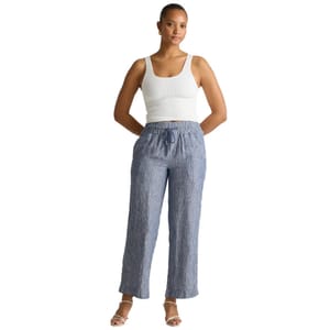 Blue-striped European linen wide-leg pants with an elastic waistband and drawstring, offering a relaxed fit. Perfect for casual wear, paired here with a white tank top and open-toe sandals.