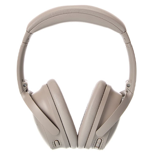 Noise-canceling over-ear headphones in a light tan color with adjustable padded headband and cushioned ear cups.
