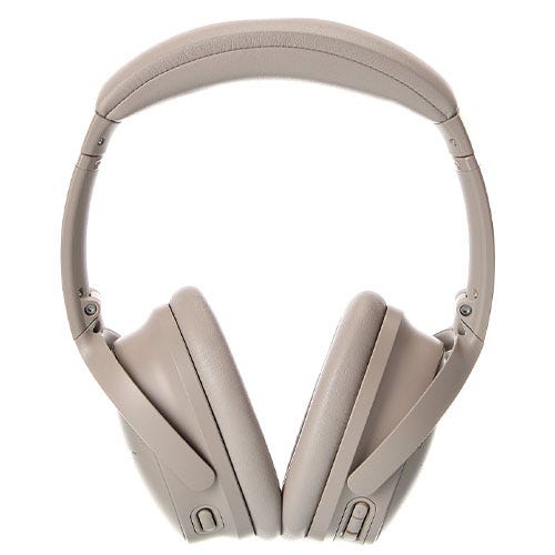 Noise-canceling over-ear headphones in a light tan color with adjustable padded headband and cushioned ear cups.