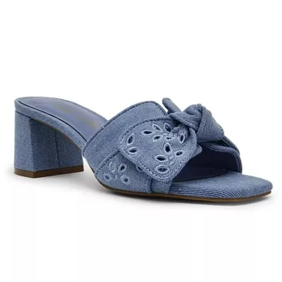 Blue denim heeled mule with a large bow detail and floral embroidery, featuring a block heel and open-toe design.