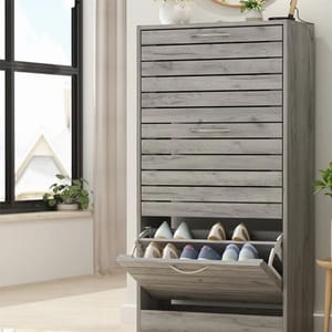 A gray wooden shoe cabinet with an open drawer revealing several pairs of shoes.
