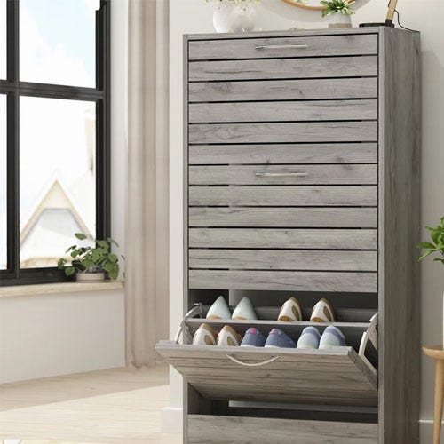 A gray wooden shoe cabinet with an open drawer revealing several pairs of shoes.