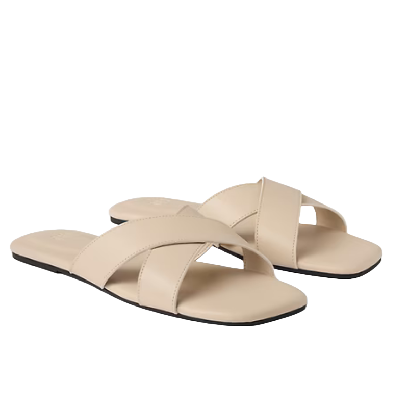 A pair of beige flat sandals with crisscross straps and a black sole.