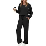 A woman is wearing a black long-sleeve top and pants set with a drawstring waist, holding a coffee cup. She has a black shoulder bag and is wearing white sneakers.