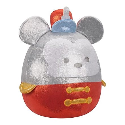 A plush toy designed as a stylized Mickey Mouse, featuring a red lower section, a silver middle section with two yellow buttons, topped with a classic Mickey ear silhouette and a blue hat.