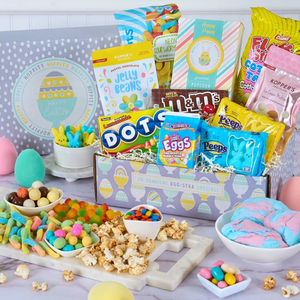 The Deluxe Easter Care Package includes pastel chocolate jelly beans, neon sour worms, lemonade Dots, egg-shaped bubble gum, Peeps, cotton candy, popcorn, M&M's, and assorted chocolates, all placed in a decorative Easter-themed box.