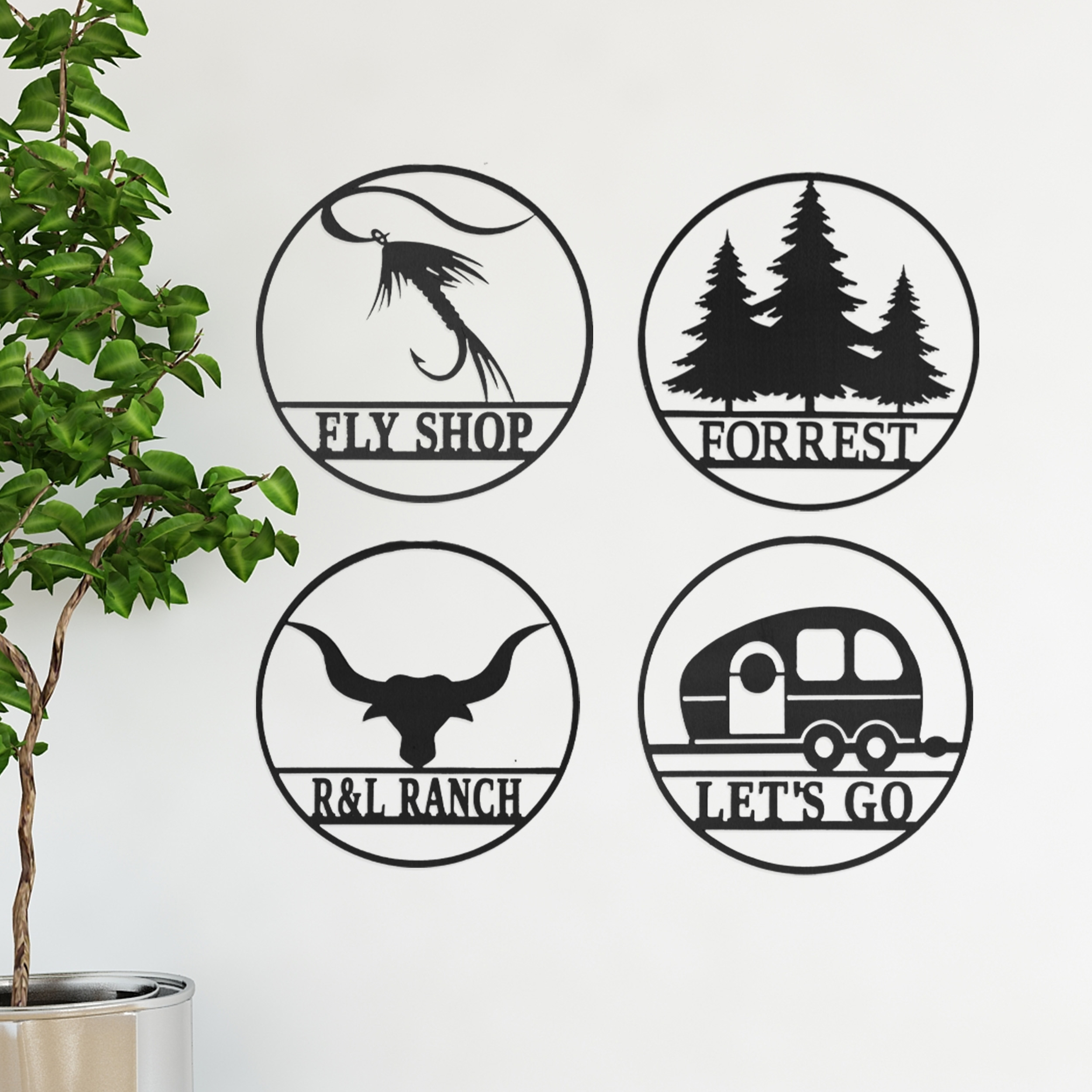 Four circular custom wall signs featuring a fly fishing hook labeled \“Fly Shop,\“ pine trees labeled \“Forrest,\“ a bull head labeled \“R&L Ranch,\“ and a camper labeled \“Let's Go,\“ all in black and white.