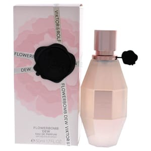 A pale pink grenade-shaped fragrance bottle with a black seal stands next to its box which has a flower pattern and displays the name \“Viktor & Rolf Flowerbomb Dew.\“