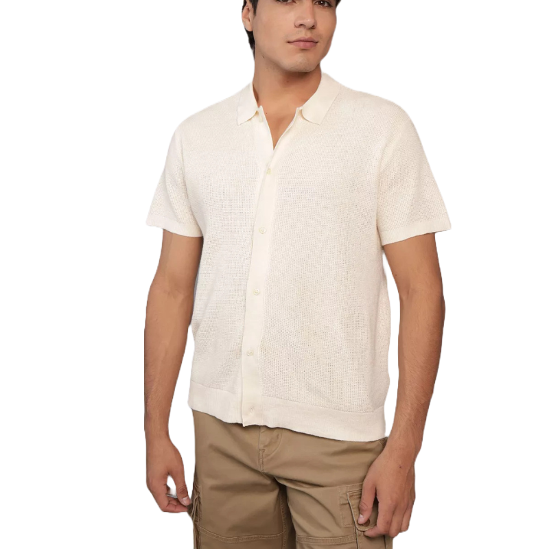 A man is wearing a short-sleeve, button-up, beige shirt paired with beige cargo shorts.