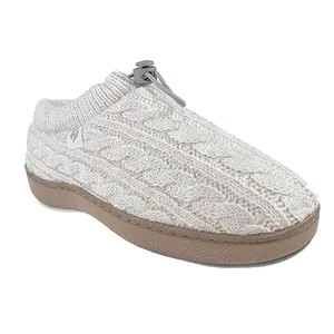 A cream-colored slipper with a cable knit design, featuring a soft upper and a thick, light-brown sole.