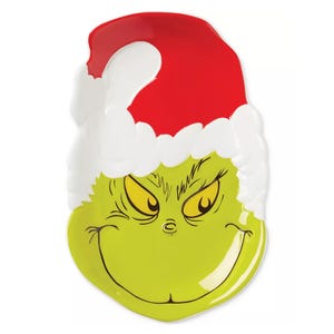 A Lenox Merry Grinchmas Candy Dish shaped like the Grinch's face, wearing a red Santa hat with white trim, featuring his mischievous grin and yellow eyes.