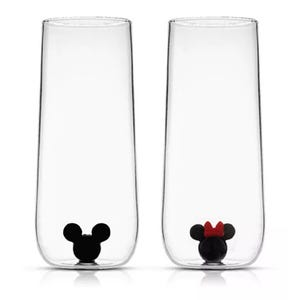 Set of two tall clear glasses with black mouse ear designs at the base; one with a red bow.