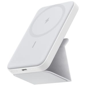 A white wireless charging power bank with a foldable stand, featuring a circle design with a lightning bolt symbol and LED indicator lights.