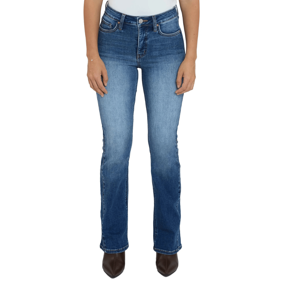 A person is wearing high-waisted, bootcut blue jeans with a slightly faded wash, paired with dark pointed-toe shoes.
