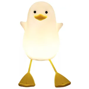 A cute penguin-shaped night light with yellow feet and a yellow beak, featuring a white glowing body.